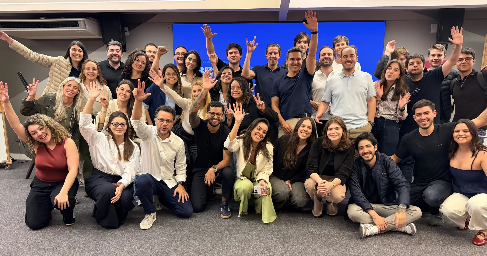 O time da Vixtra reunido no escritório, de braços erguidos.