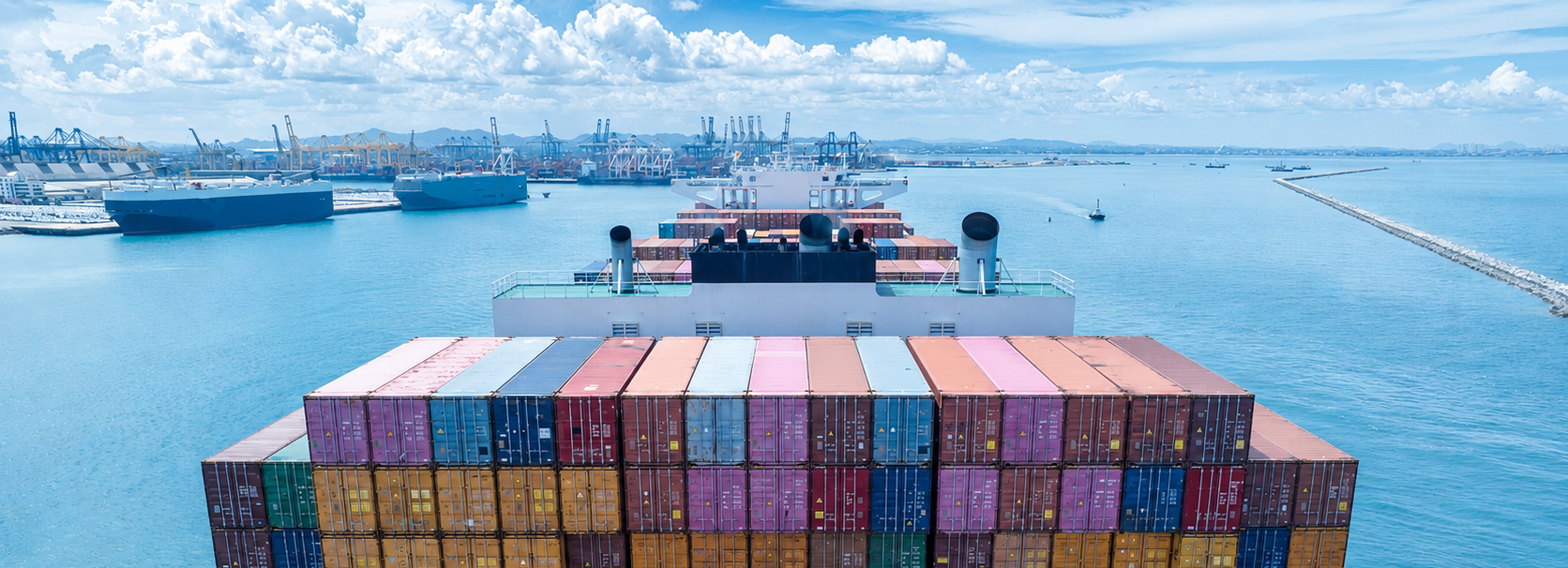 Navio cargueiro chegando ao porto com containers, ilustrando o uso da carga em trânsito como garantia de crédito para importação