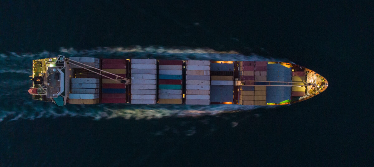 Navio cargueiro atravessando o oceano à noite